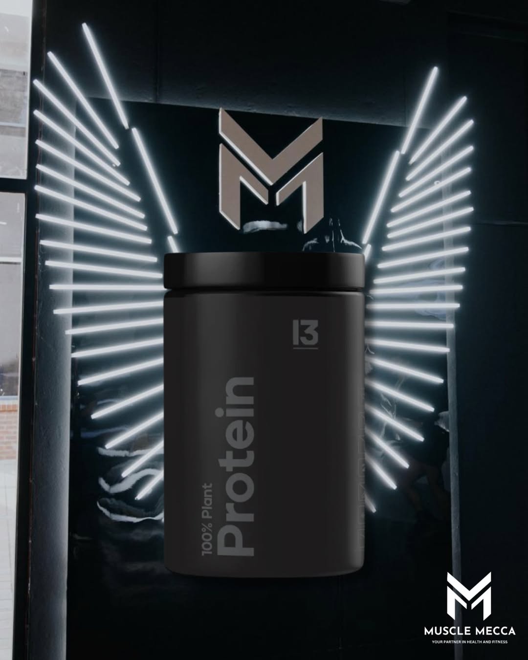 Black protein container with 'Muscle Mecca' branding against a dark background with illuminated wings.