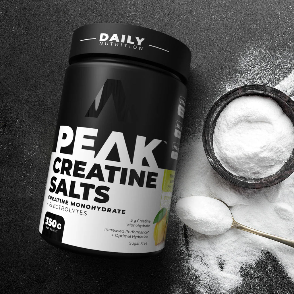 Container of Peak Creatine Salts with a scoop of powder on a dark background Muscle Mecca